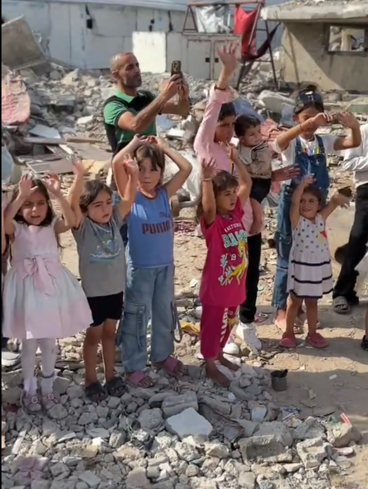 Children dancing among the ruins of Gaza