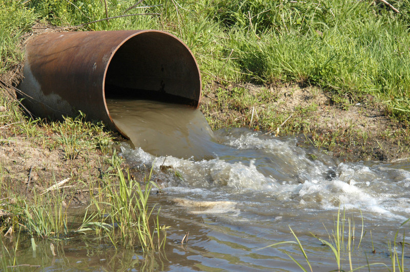 Shit pouring out of a sewage works into a river